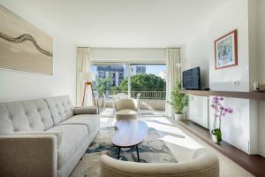 Agence des Résidences - Plein centre de Cannes في كان: غرفة معيشة مع أريكة وطاولة