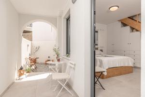 a room with a bed and a table and chairs at All senses studio in Naxos Chora