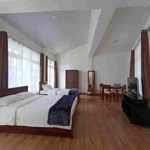 a large bedroom with two beds and a table at Edelweiss in Kohīma