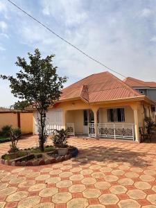 a house with a tile roof and a tree in front of it at Villa Soto in Conakry