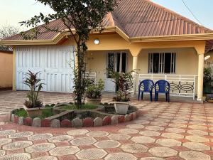 a house with two blue chairs in front of it at Villa Soto in Conakry