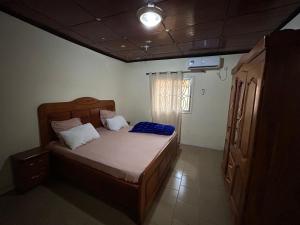 a bedroom with a bed with a blue blanket on it at Villa Soto in Conakry