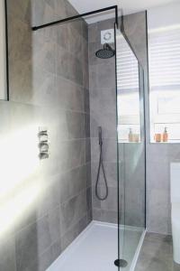 a shower with a glass door in a bathroom at Inverkar Mews Cottage, Ayr - SA-00520-F in Ayr