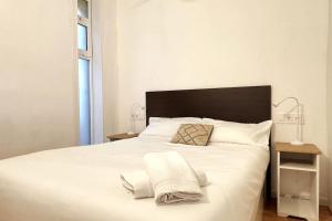 a bedroom with a white bed with two towels on it at Panoramic view Gavà Mar in Gavà