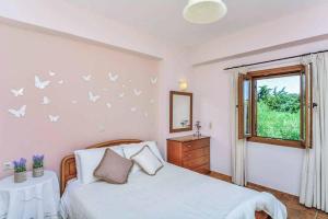 a bedroom with a bed with butterflies on the wall at Villa Meli in Methoni +48 photos