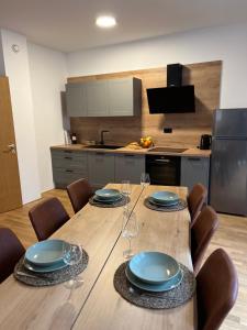 a kitchen with a table with plates and wine glasses at Foxi apartment, Pohorje in Hočko Pohorje