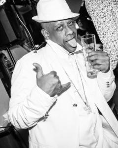 a man in a hat holding a glass of wine at FLAT Calais beach in Calais +27 photos