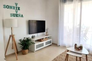 uma sala de estar com televisão num armário branco em Big terrace in modern apartment close to the beach em Oropesa del Mar