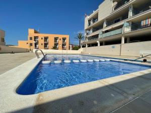 uma piscina em frente a um edifício em Big terrace in modern apartment close to the beach em Oropesa del Mar