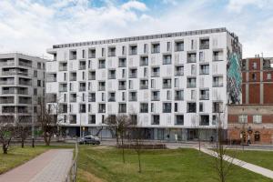 a white building with many windows on a city street at Unique Apartment with Balcony & Parking Zabłocie Cracow by Renters Prestige in Krakow