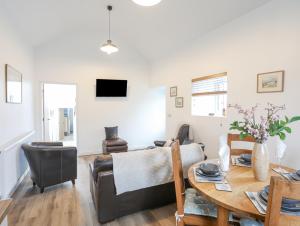 a living room with a table and a couch at Ty Den in Caernarfon
