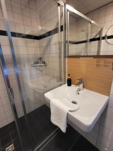 La salle de bains blanche est pourvue d'un lavabo et d'une douche. dans l'établissement Landhotel Diever, à Diever