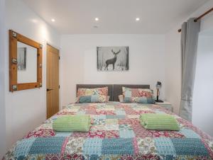 a bedroom with a bed with a quilt on it at Ty Den in Caernarfon