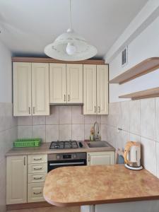 a kitchen with white cabinets and a stove top oven at Nocleg w Kraśniku in Kraśnik