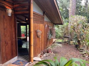 a wooden house with a porch and a patio at My Mountain Home - Le Studio in Taravao