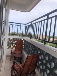 2 Stühle und ein Tisch auf einem Balkon mit Aussicht in der Unterkunft Leisure apartment in Mombasa