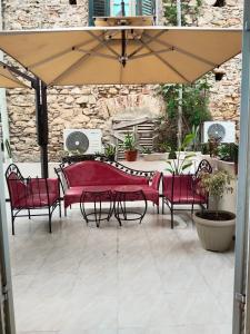 una mesa y sillas bajo una sombrilla en un patio en Hotel Marhaba - Beb Bhar Tunis en Túnez