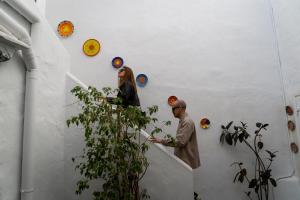 mężczyzna i kobieta stojący na klatce schodowej w obiekcie Apartamento Trafalgar By La Juderia De Vejer - Inside a typical Andalusian Casa Patio w mieście Vejer de la Frontera