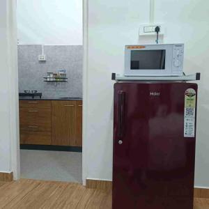 a microwave on top of a refrigerator in a kitchen at Edelweiss in Kohīma +6 photos