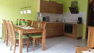 オストゼーバート・カールスハーゲンにあるFewo Sommergarten 4004_FIEBのキッチン(木製のテーブルと椅子付)