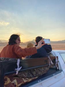 two people sitting in the back of a car taking a picture at Wadi Rum Desert Bedouins in Wadi Rum