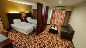 a hotel room with a bed and a chair at SUN GARDEN Studio and Residences at South China Sea Place Suites in Kota Kinabalu