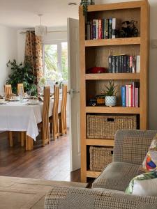 a dining room with a table and a book shelf with books at ROSE COTTAGE in Ryde