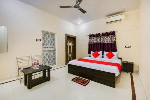 a bedroom with a bed and a table and a window at Super OYO Flagship Hotel Rudraksh Inn in Rānchī