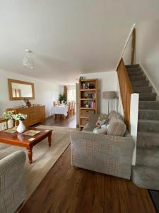 ein Wohnzimmer mit einer Treppe und einer Couch in der Unterkunft ROSE COTTAGE in Ryde