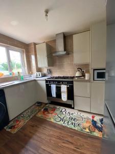 a kitchen with a stove and a rug on the floor at ROSE COTTAGE in Ryde
