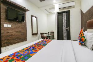 a bedroom with a bed and a tv on the wall at FabHotel La Vista in Zirakpur