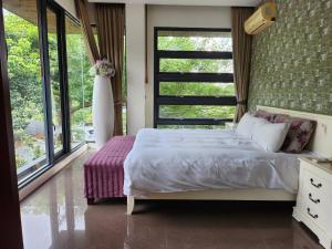 a bedroom with a bed and a large window at Zhe Juan Meng Tian in Sanyi