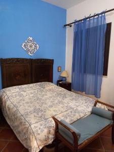 ein Schlafzimmer mit einem Bett und einer blauen Wand in der Unterkunft Villa Maruzza (Sicilia Bedda) in Carini