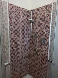 ein Bad mit einer Dusche und einer gefliesten Wand in der Unterkunft Villa Maruzza (Sicilia Bedda) in Carini