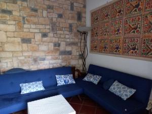 ein blaues Sofa in einem Zimmer mit Ziegelwand in der Unterkunft Villa Maruzza (Sicilia Bedda) in Carini