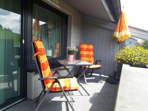 un patio avec deux chaises, une table et un parasol dans l'établissement Ferienwohnungen Bußmann, à Herscheid