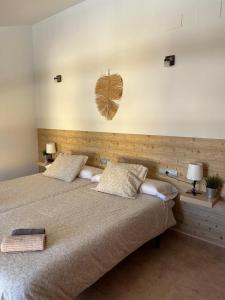 a bedroom with a large bed with two pillows at Hostal Espai Mediterrani in Puebla de Vallbona