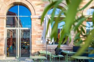 uma pessoa sentada à mesa em frente a um prédio em The People - Strasbourg em Estrasburgo