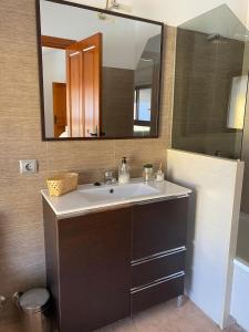 a bathroom with a sink and a large mirror at Hostal Espai Mediterrani in Puebla de Vallbona