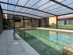 a swimming pool with a retractable roof over it at Casa Enrique: familias y grupos! in Murias de Pedredo