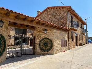 a stone building with a gate in front of it at Casa Enrique: familias y grupos! in Murias de Pedredo