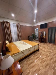 um quarto com uma cama grande e piso em madeira em Bana Home & Spa em Hoi An