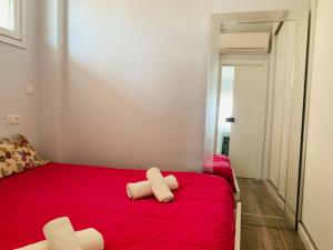 1 dormitorio con 1 cama roja y 2 toallas blancas en GLP SAN JUAN BEACH, en El Campello