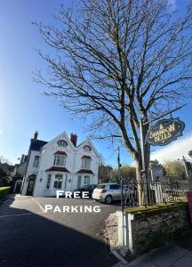 un letrero de aparcamiento gratuito frente a una casa blanca en Shandon Bells Guest House, en Cork