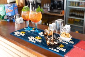 a bar with two drinks and snacks on a counter at Hotel Bolivar in Marina di Camerota