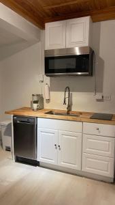 uma cozinha com armários brancos, um lavatório e um micro-ondas em Paradise Villa em Nassau