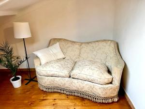 um sofá sentado numa sala de estar com um candeeiro em BellaLimone em Calatabiano