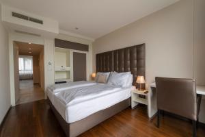 1 dormitorio con 1 cama grande y escritorio en Pakat Residences en Viena