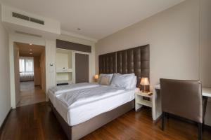 a bedroom with a large bed and a desk at Pakat Residences in Vienna