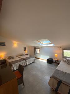 a bedroom with two beds and a skylight at Hôtel Restaurant Petra Cinta in Barcaggio